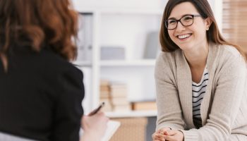 Happy,Woman,During,Successful,Psychotherapy,With,Counselor,At,Clinic