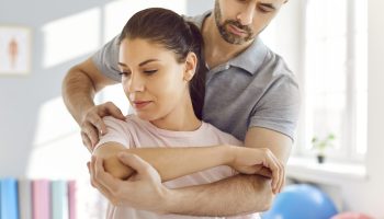 Young,Male,Professional,Chiropractor,Or,Physical,Therapist,Working,With,Caucasian