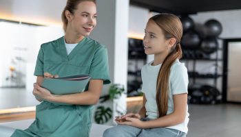 Woman,Therapist,And,Child,Sitting,Communicating,Before,Physical,Therapy,Session