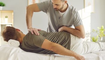 Professional,Doctor,,Chiropractor,,Osteopath,Or,Physiotherapist,,Helping,Man,Patient,With